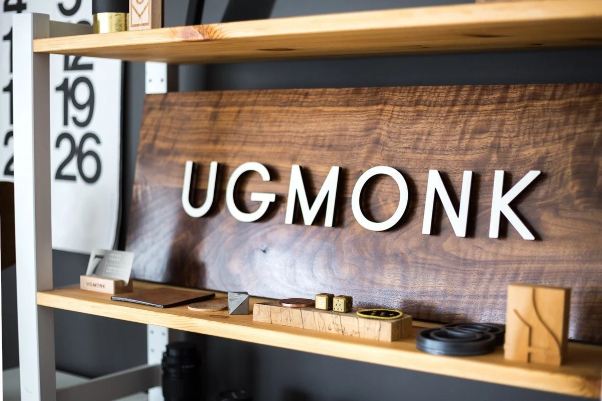 A wooden UGMONK sign on a shelf in the home office